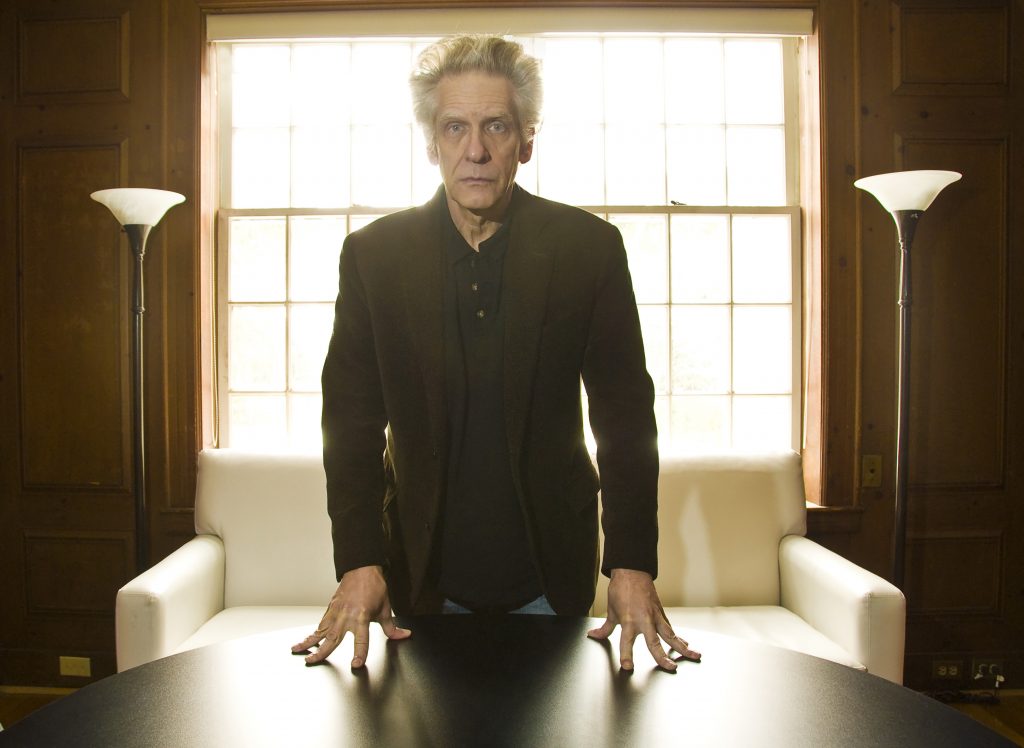 Davind Cronenberg standing at a table